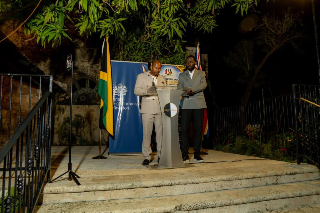 Co-founders Nathaniel Peat and Khori Hyde at the podium beneath the Jamaican and British flags